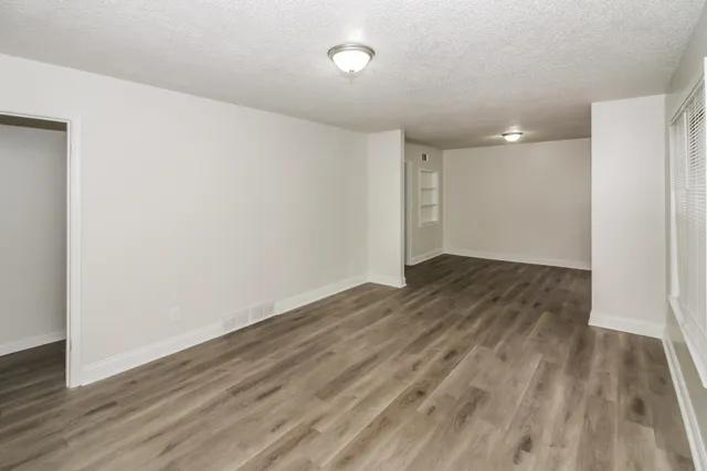 a view of an empty room with wooden floor