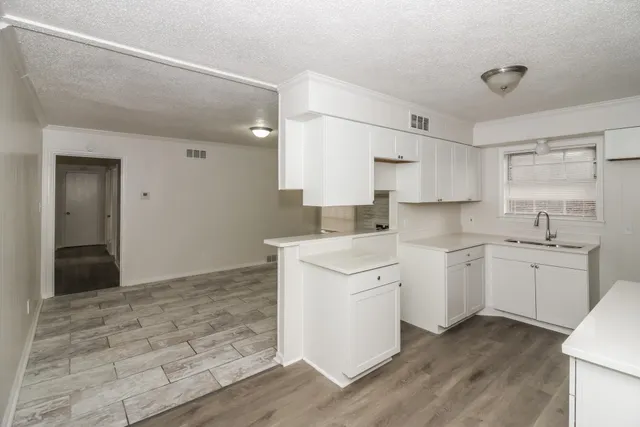 a kitchen with granite countertop white cabinets and white appliances