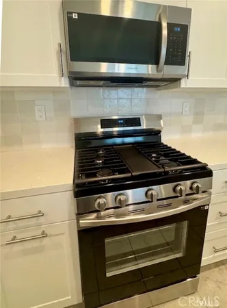 a stove top oven sitting inside of a kitchen