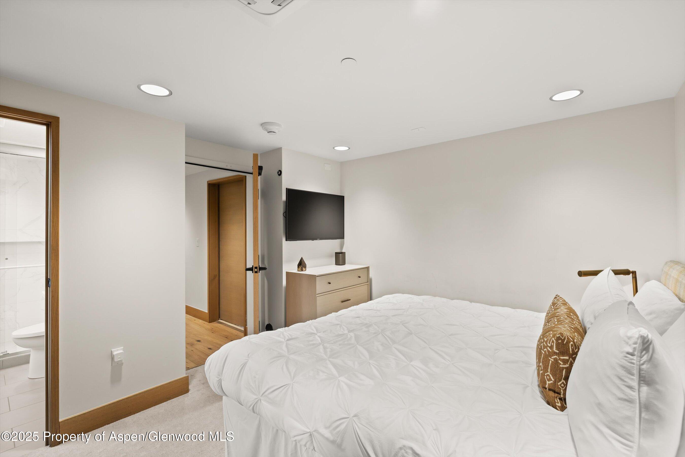 122 West Main Street Aspen, CO 81611 - Photo 13 of 58 a bedroom with a bed and a flat screen tv