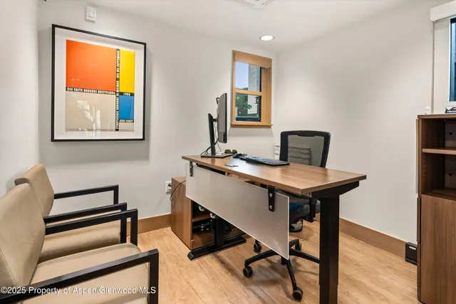 a view of a workspace with furniture and a window