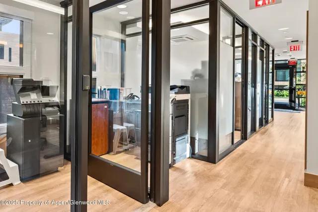 a view of a hallway with wooden floor and windows