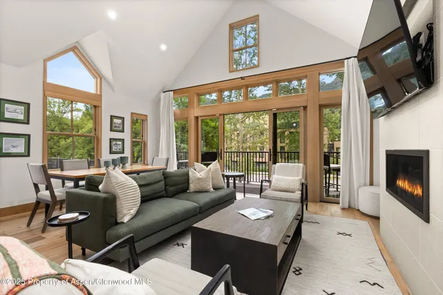 a living room with furniture a large window and a flat screen tv