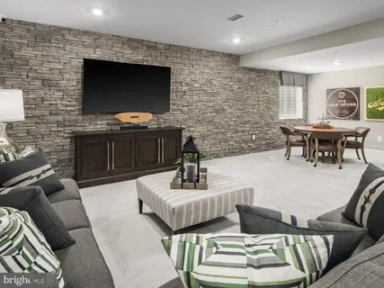 a living room with furniture a flat screen tv and kitchen view