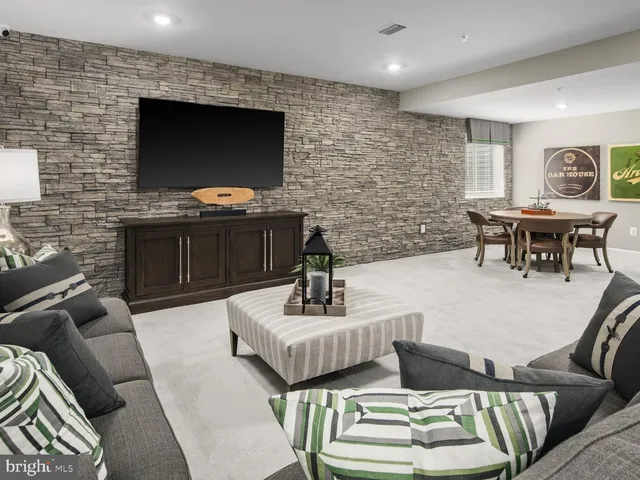 a living room with furniture a flat screen tv and kitchen view