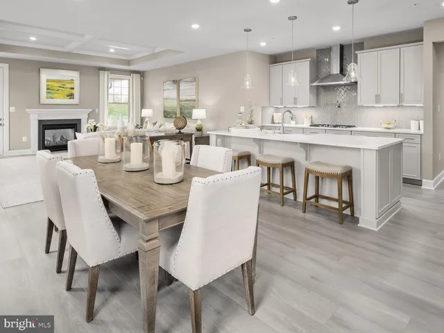 a dining room with kitchen island furniture a wooden floor and a fireplace