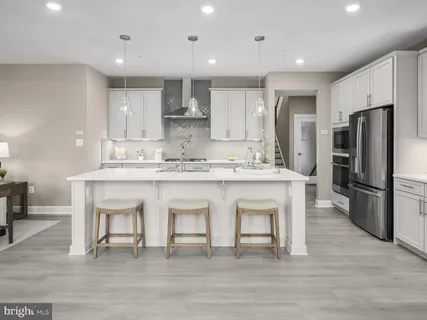 a kitchen with stainless steel appliances granite countertop a white cabinets and a refrigerator
