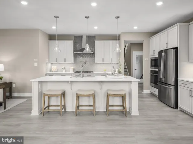 a kitchen with stainless steel appliances granite countertop a white cabinets and a refrigerator