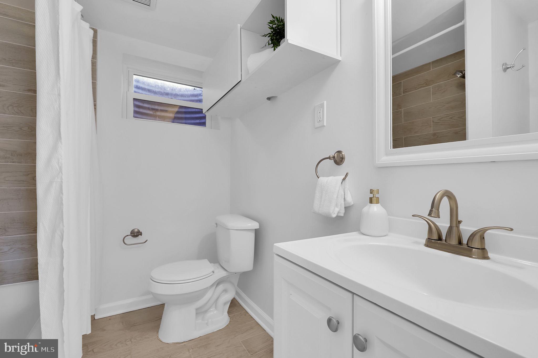 1009 Stirling Road Silver Spring, MD 20901 - Photo 21 of 33 a bathroom with a toilet sink and mirror