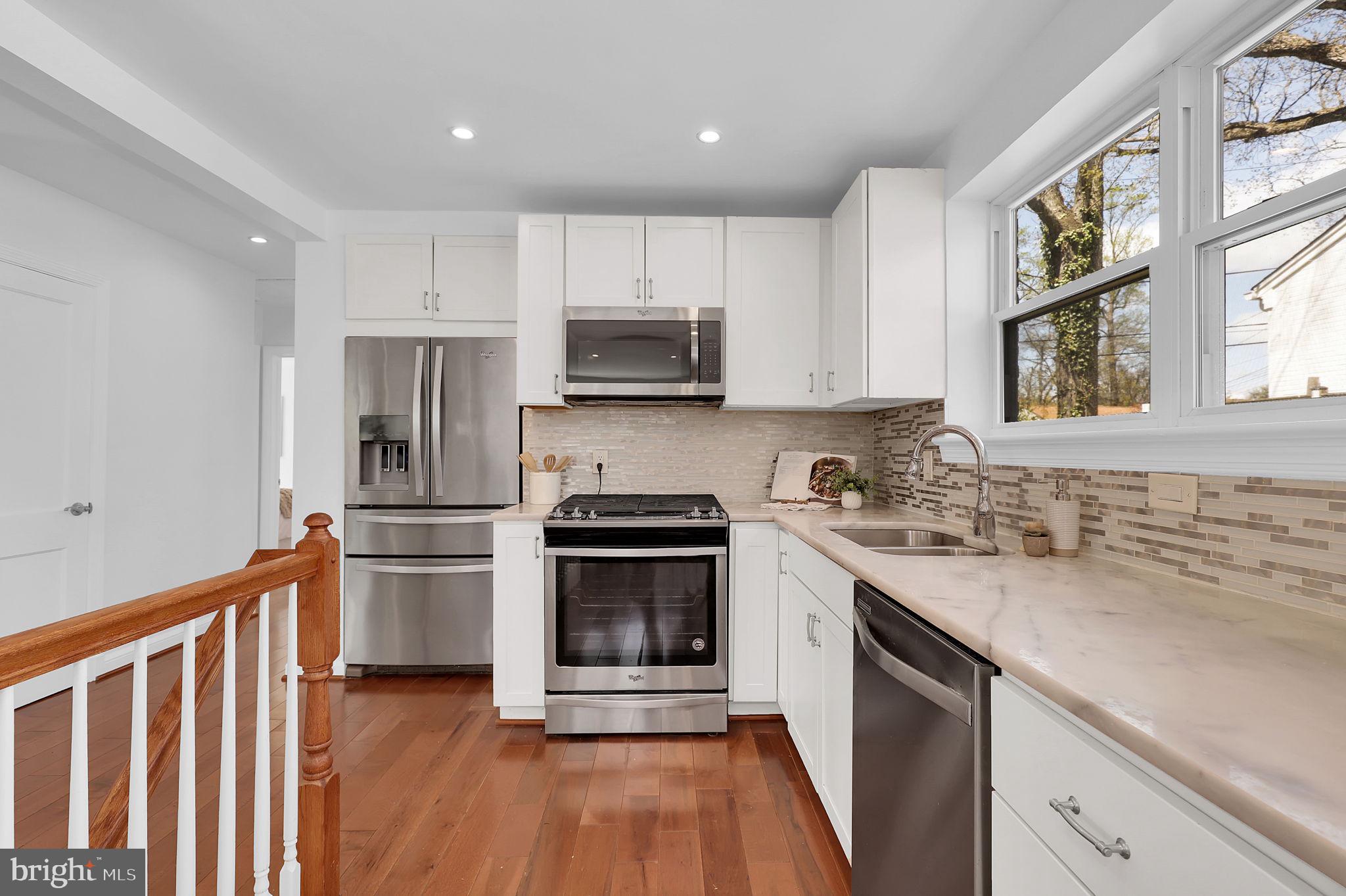 1009 Stirling Road Silver Spring, MD 20901 - Photo 8 of 33 a kitchen with stainless steel appliances granite countertop a stove a sink and a refrigerator