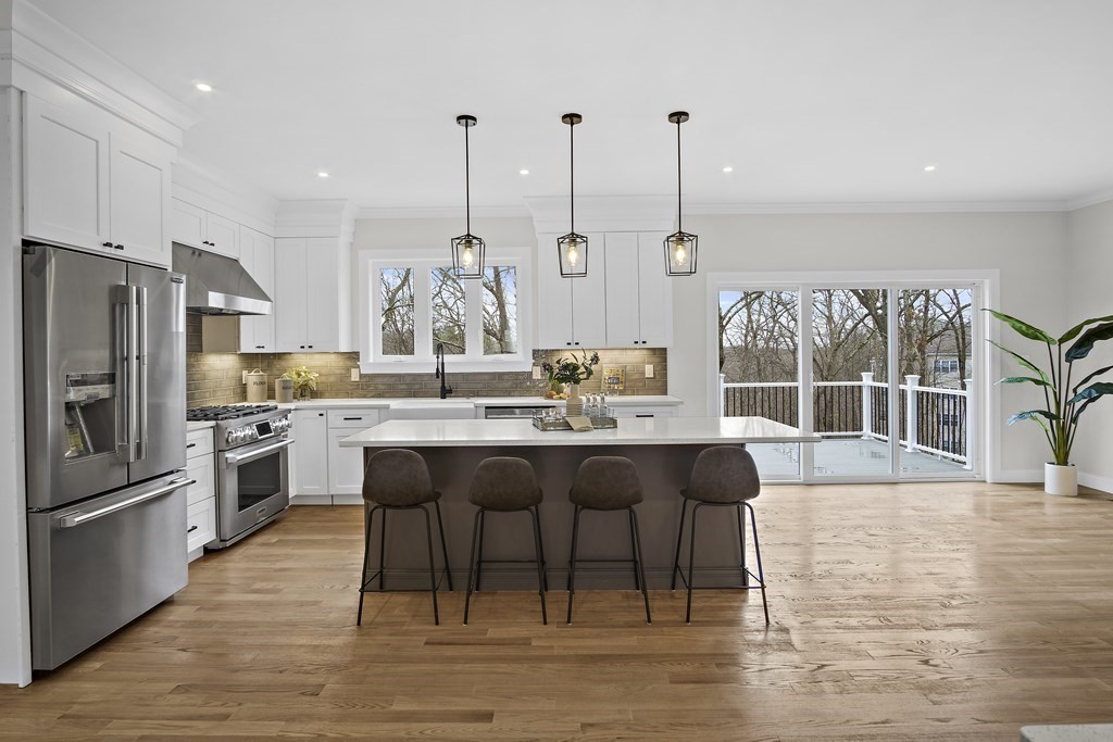 41 Peach Orchard Road Burlington, MA 01803 - Photo 12 of 42 a kitchen with stainless steel appliances granite countertop a table chairs stove and kitchen view