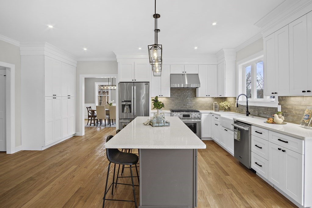 41 Peach Orchard Road Burlington, MA 01803 - Photo 13 of 42 a kitchen with stainless steel appliances a dining table chairs stove refrigerator and cabinets