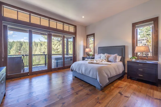 a bedroom with a large bed and wooden floor