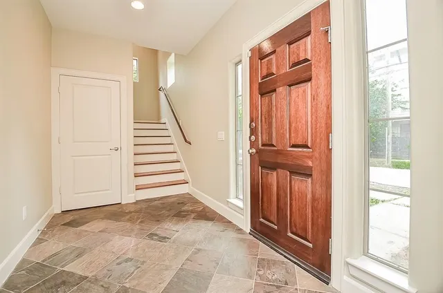 a view of a hallway with entryway wooden floor and door
