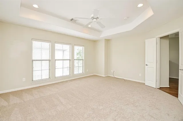 a view of an empty room with a chandelier fan