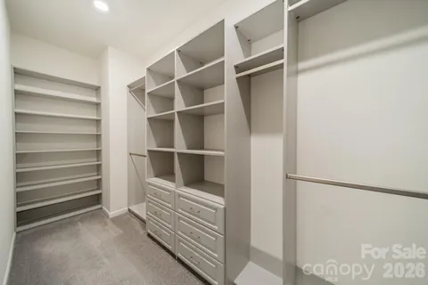 a view of walk in closet with empty racks