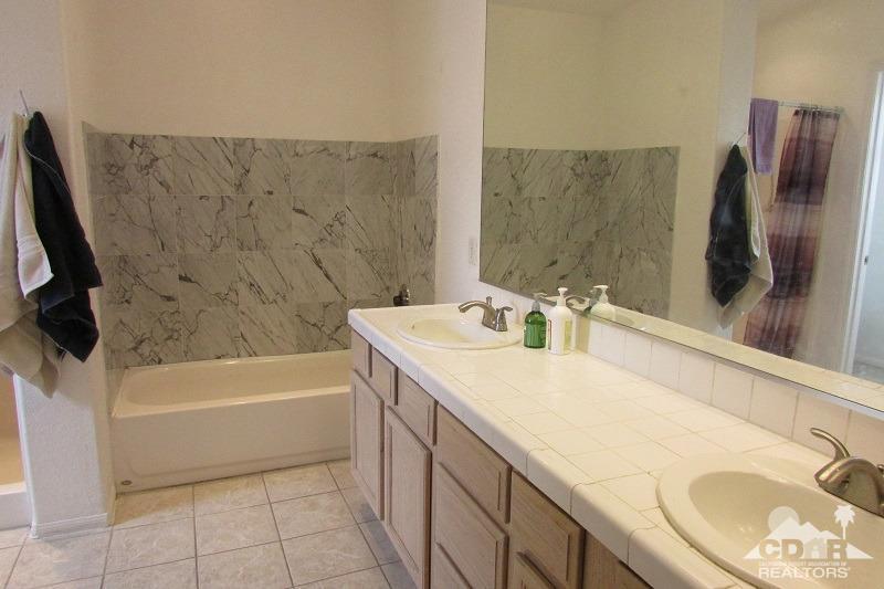 68786 Ocotillo Road Cathedral City, CA 92234 - Photo 19 of 32 a bathroom with a granite countertop sink and a bathtub