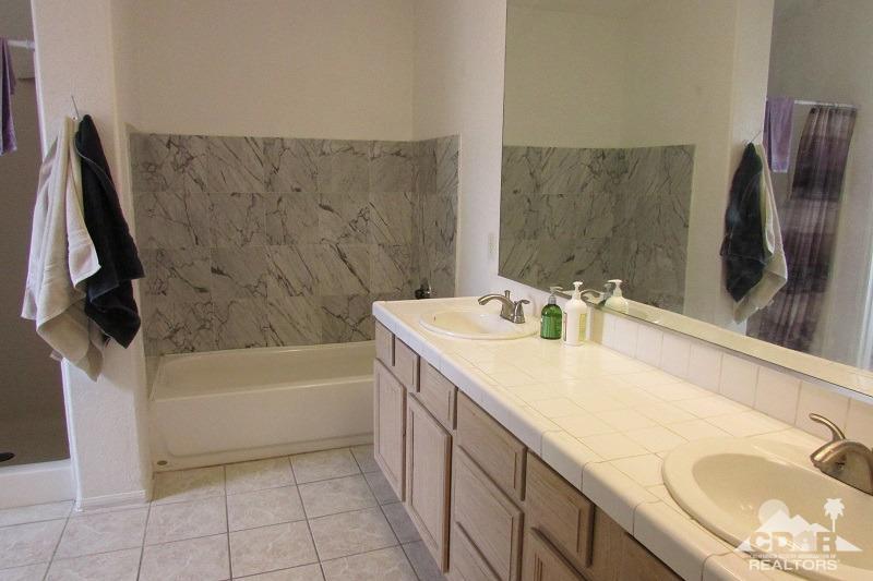 68786 Ocotillo Road Cathedral City, CA 92234 - Photo 20 of 32 a bathroom with a granite countertop sink a toilet and bathtub