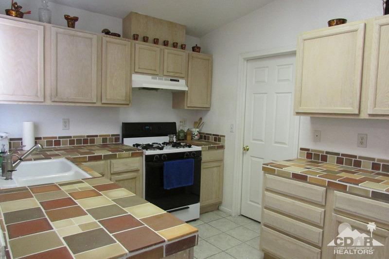 68786 Ocotillo Road Cathedral City, CA 92234 - Photo 7 of 32 a kitchen with granite countertop stainless steel appliances a stove a sink and a microwave