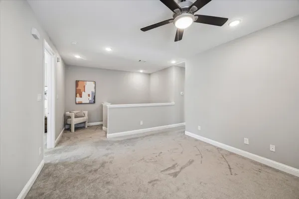 an empty room with fan and windows