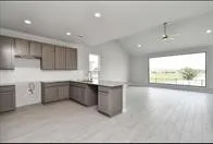 a kitchen with stainless steel appliances a large counter top a stove a sink a refrigerator and a window