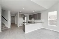 a view of large kitchen with refrigerator and window