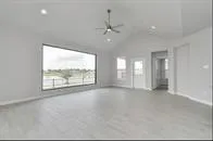 an empty room with large windows and a television