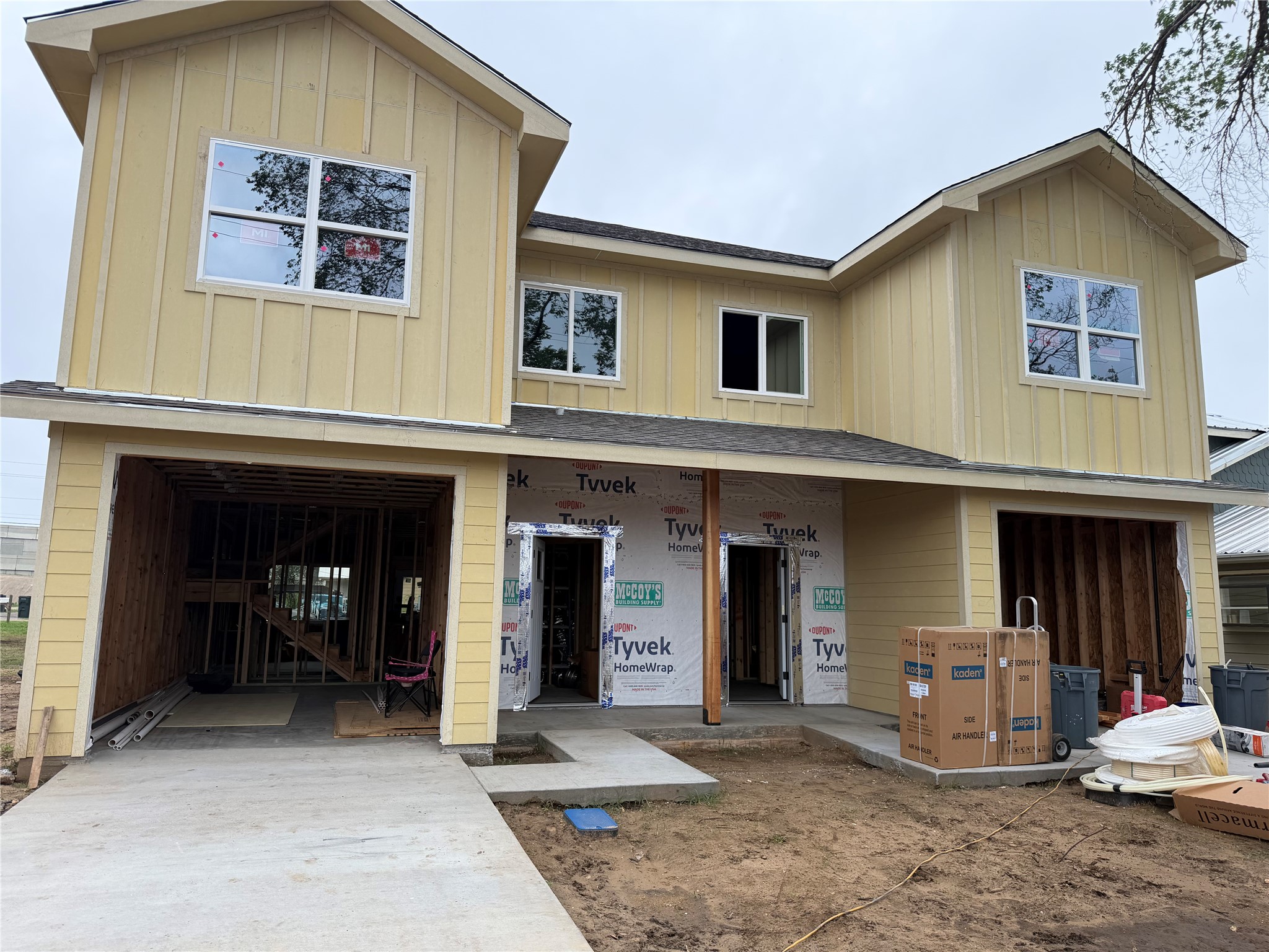 The property features a two-story design with yellow siding and multiple windows
