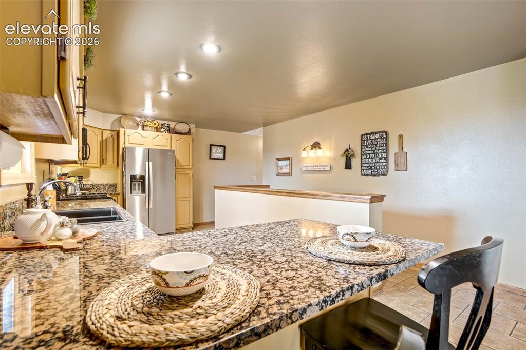 7585 Ponca Road Colorado Springs, CO 80908 - Photo 3 of 49 breakfast bar, granite counters