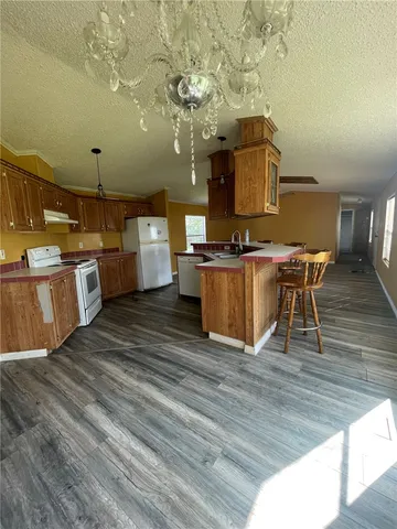 a kitchen with stainless steel appliances wooden floor dining table chairs and granite counter tops