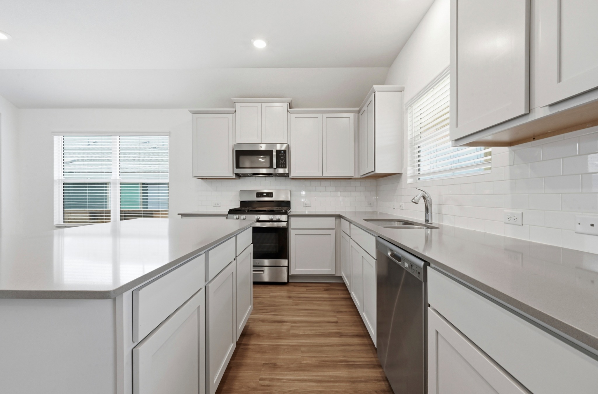 388 Barcelona Kyle, TX 78640 - Photo 11 of 26 a kitchen with stainless steel appliances a sink dishwasher a stove top oven a refrigerator and white cabinets