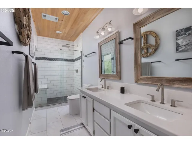 a bathroom with a double vanity sink mirror and toilet