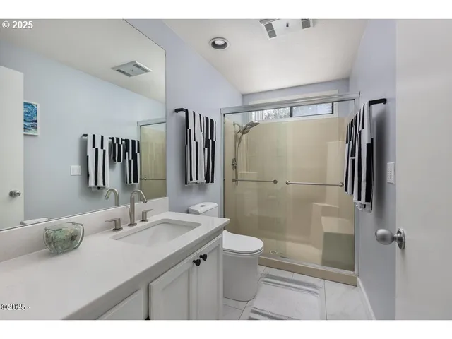 a bathroom with a sink mirror toilet and shower