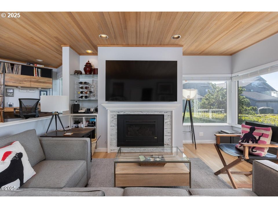 4175 Highway 101, Unit A1 Depoe Bay, OR 97341 - Photo 6 of 29 a living room with furniture a flat screen tv and a fireplace