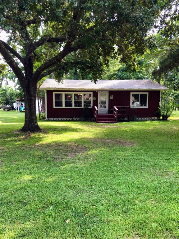 114 River Road Goodrich, TX 77335 - Photo 1 of 1 Ranch-style home featuring a front lawn and board and batten siding