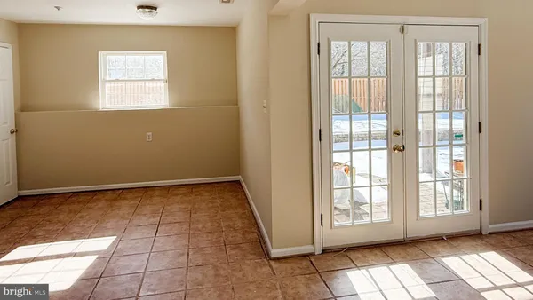 a view of an empty room with window and chandelier fan