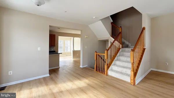 a view of a hallway with wooden floor and staircase