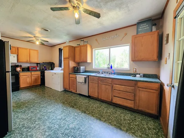 a kitchen with granite countertop a sink stainless steel appliances and cabinets