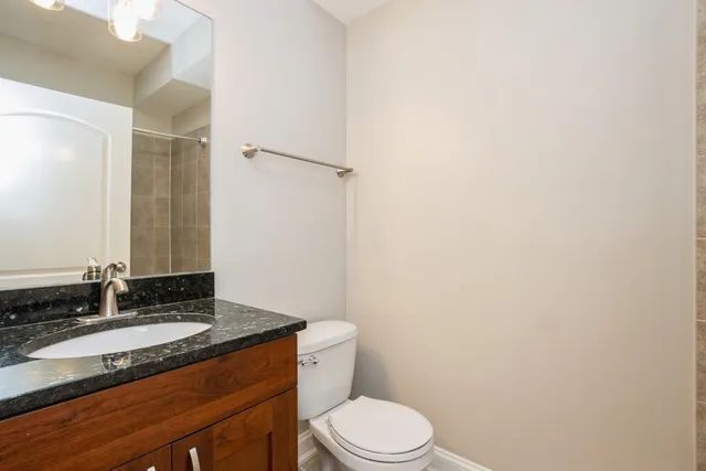 a bathroom with a granite countertop sink toilet and shower