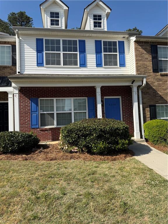 6370 Olmadison Place Atlanta, GA 30349 - Photo 1 of 15 a front view of a house with a garden