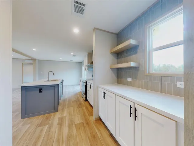a kitchen with cabinets a sink and wooden floor