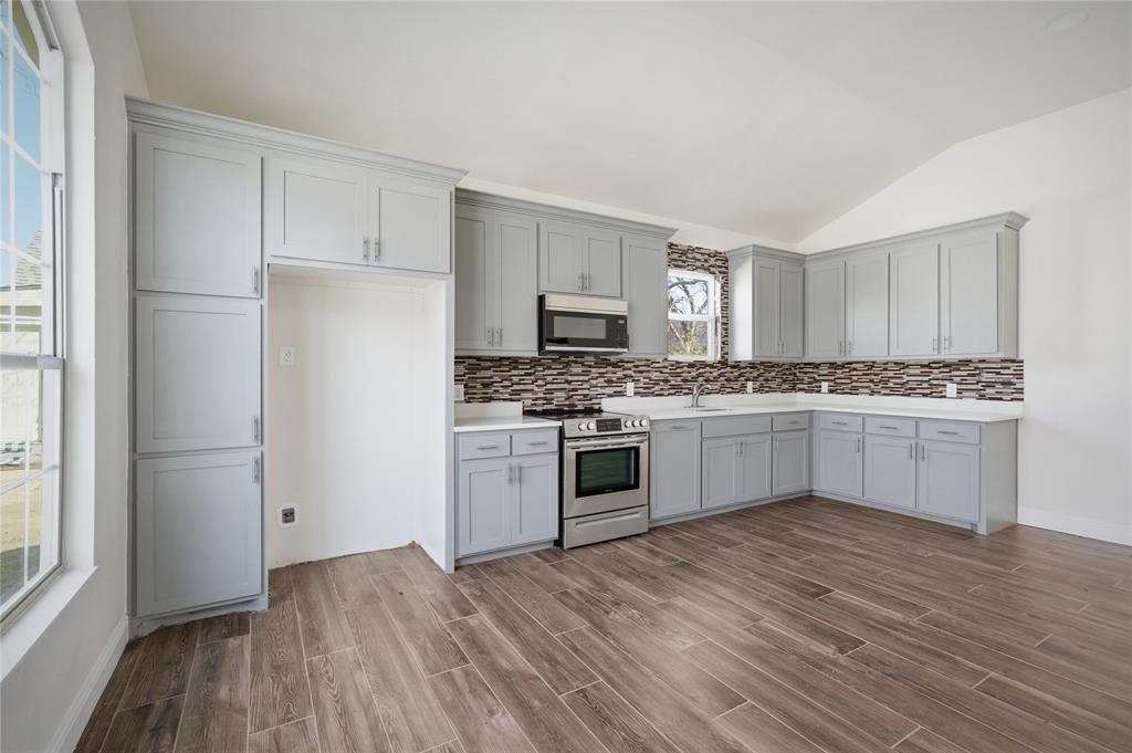 1905 South Walnut Street Sherman, TX 75090 - Photo 7 of 22 a kitchen with a refrigerator stove and white cabinets