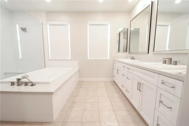 a spacious bathroom with a tub shower and a sink