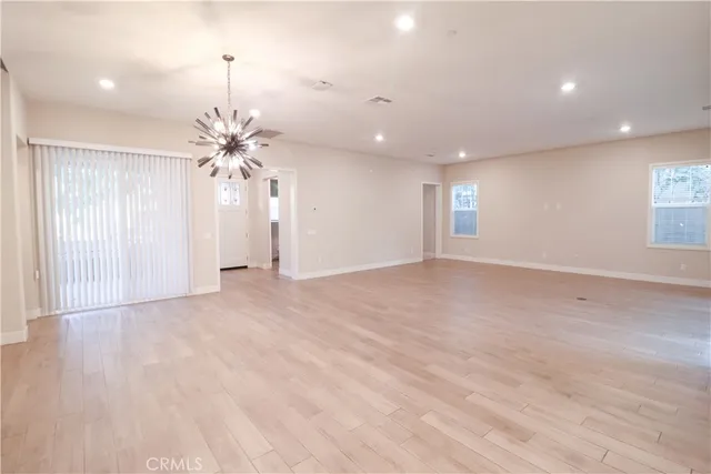 an empty room with wooden floor and entryway