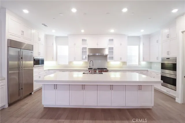 a large kitchen with kitchen island a counter top stainless steel appliances and cabinets