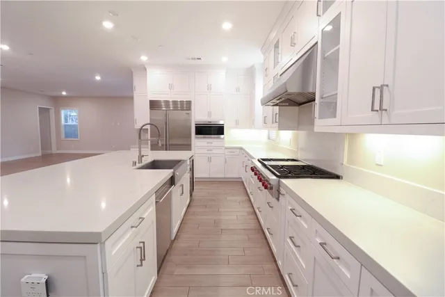 a large kitchen with stainless steel appliances lots of counter space and a sink
