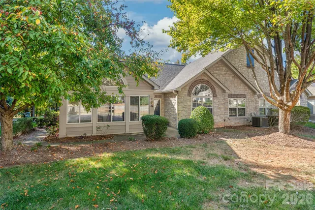a view of a yard in front of a house with large windows