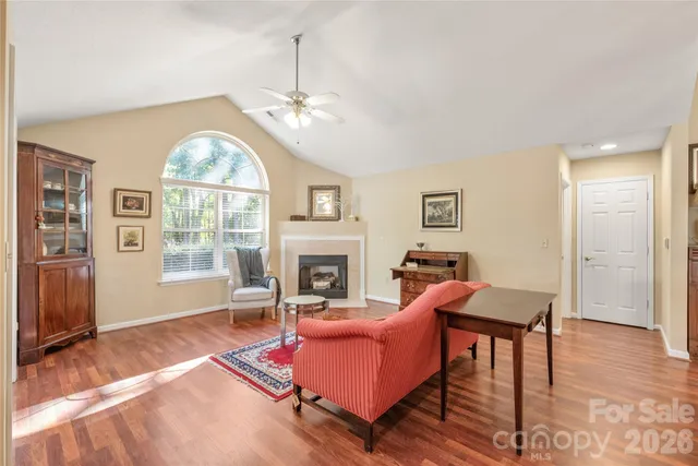 a living room with furniture a fireplace and a chandelier
