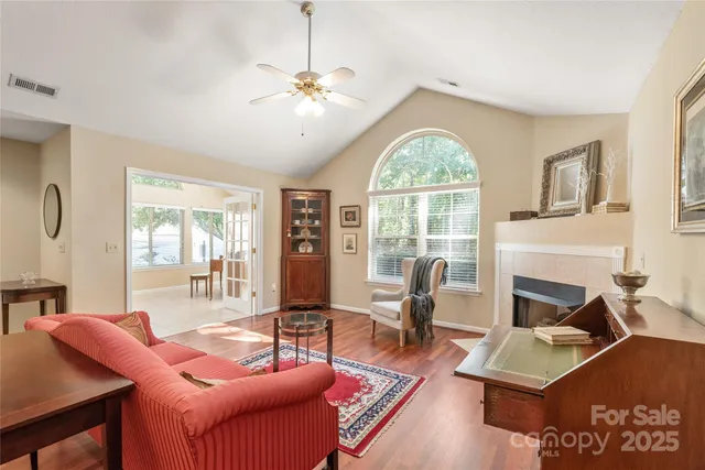 a living room with furniture a fireplace and large windows