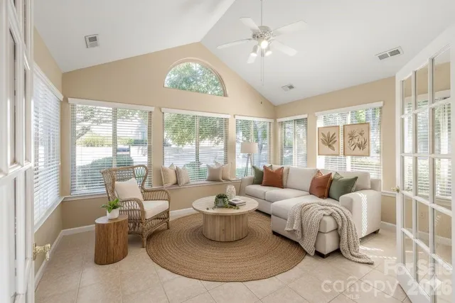 a living room with furniture a chandelier and a large window